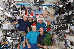 Expedition 30 crew with Santa Claus hats.jpg